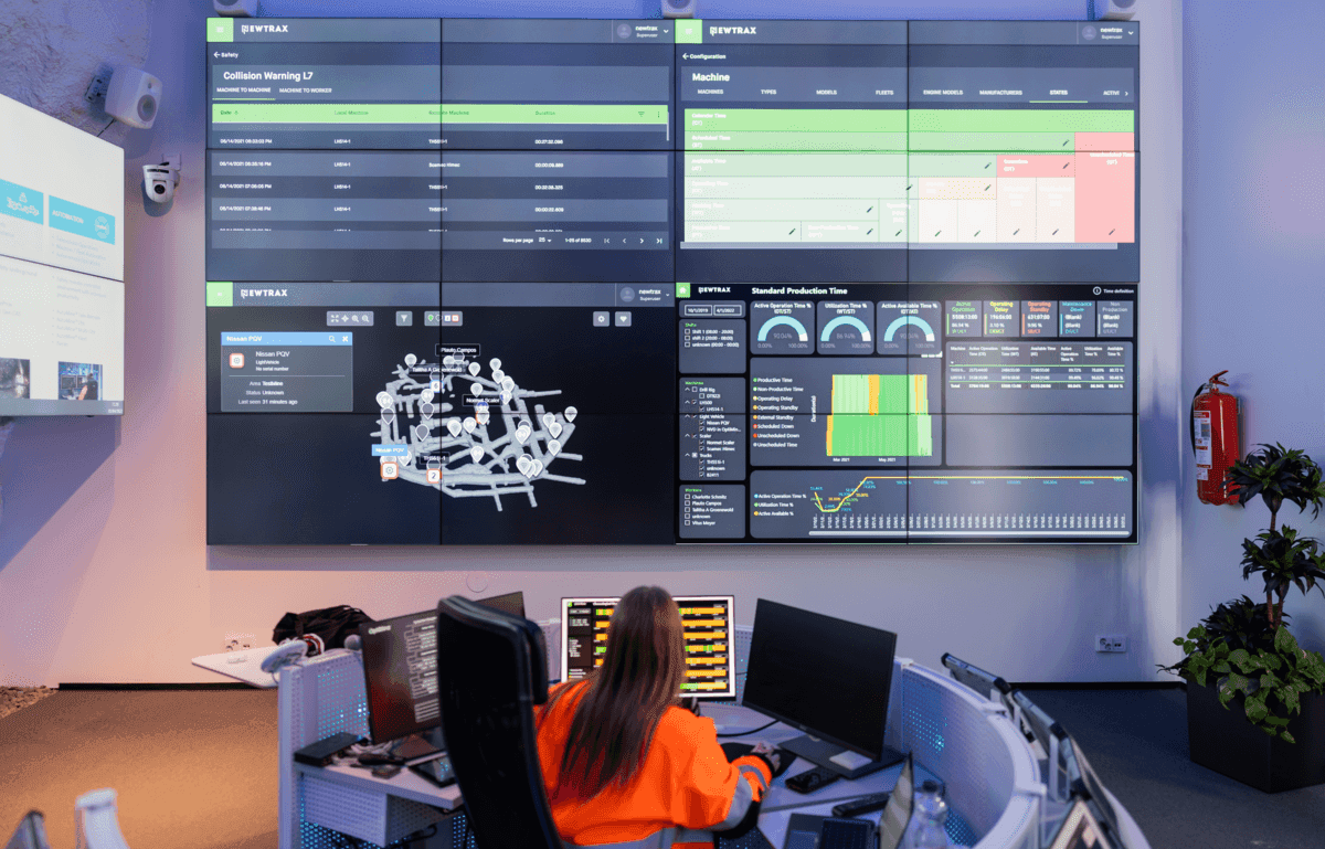 A worker looking at a large screen with the Newtrax dashboards